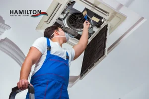 HVAC technician performing AC Repairs in Hamilton on residential air conditioning unit