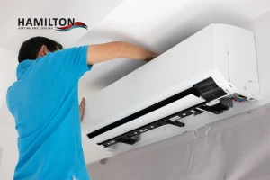 AC repair Hamilton — HVAC technician inspecting outdoor air conditioner unit